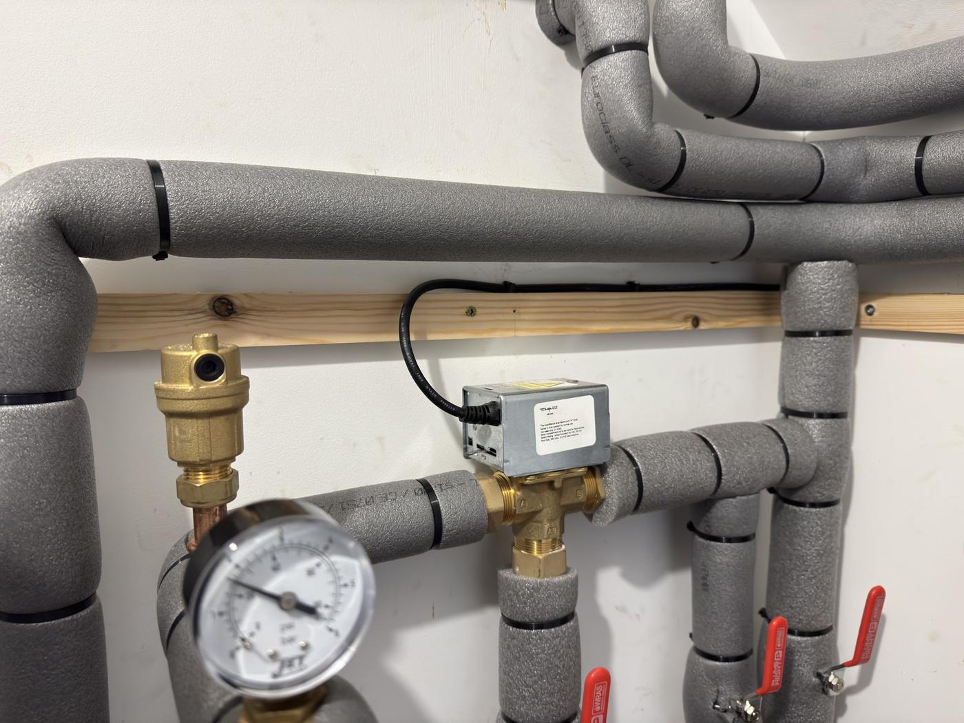 System pressure gauge and automatic air vent on insulated pipework