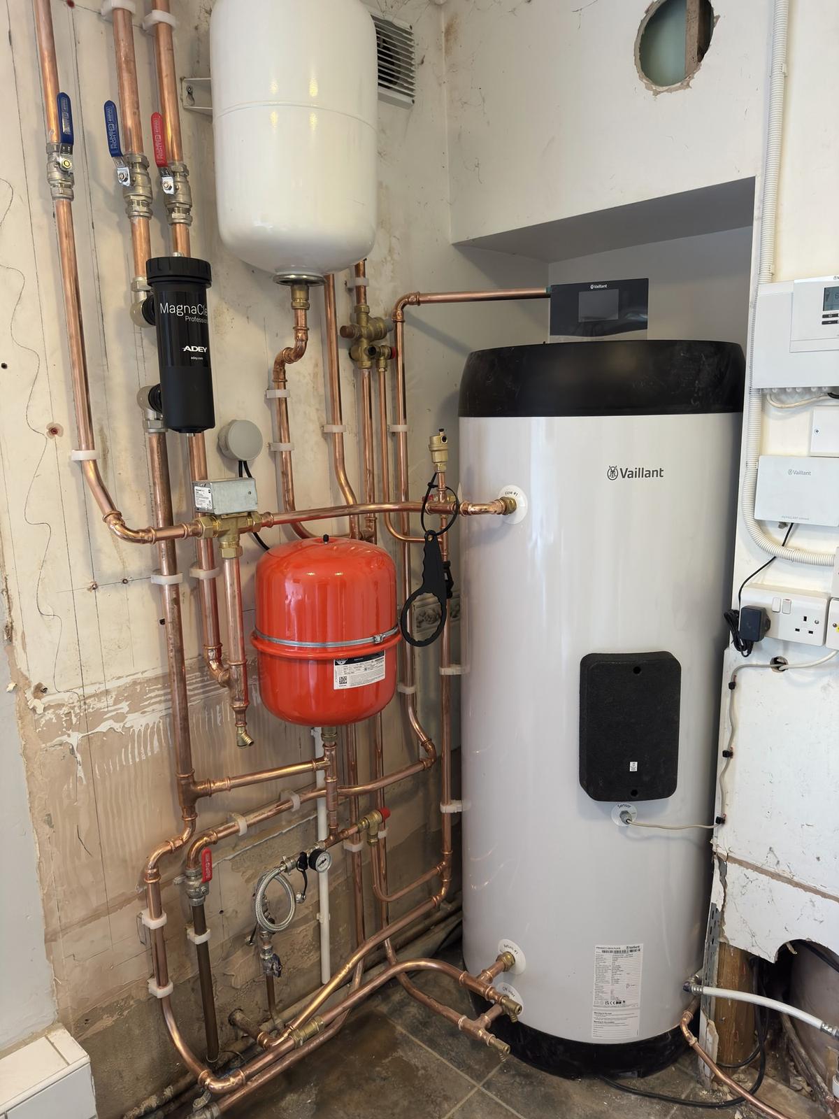 Vaillant hot water cylinder with its expansion vessel, filter and pipework in a plant cupboard