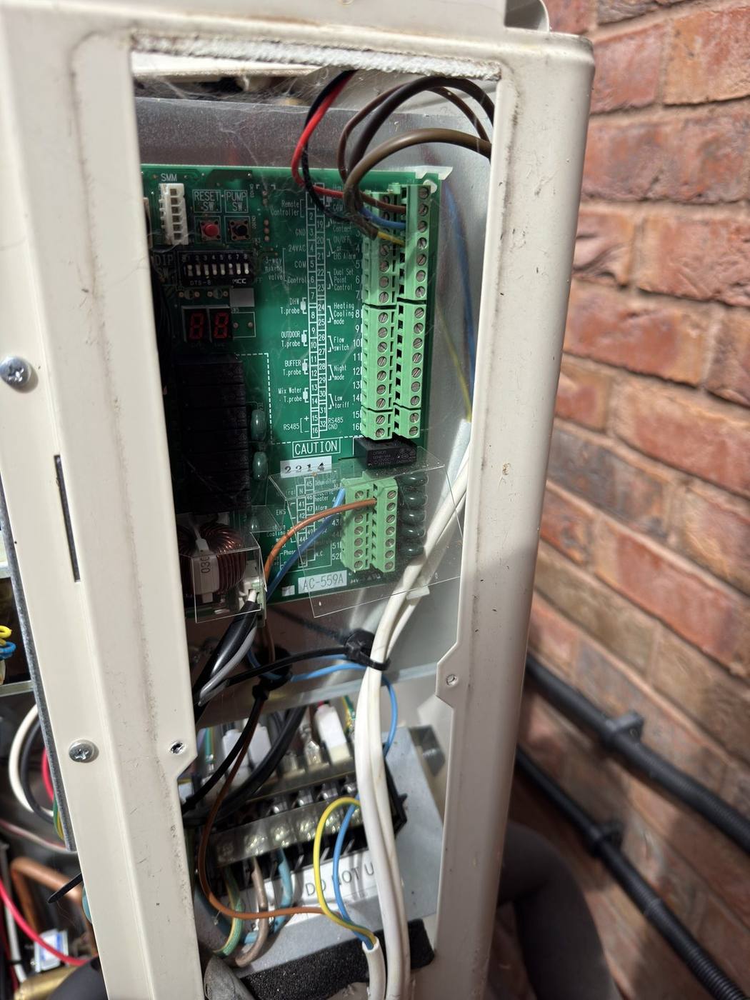 Heat pump control box opened up during fault finding, circuit board and wiring visible