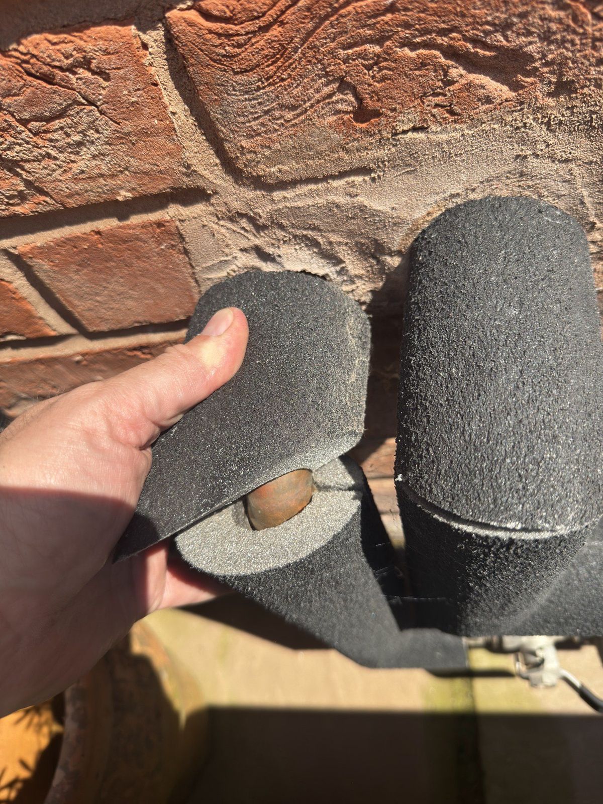 Pipe insulation lifted away to show the bare pipework underneath, found during a service on a system installed by another company