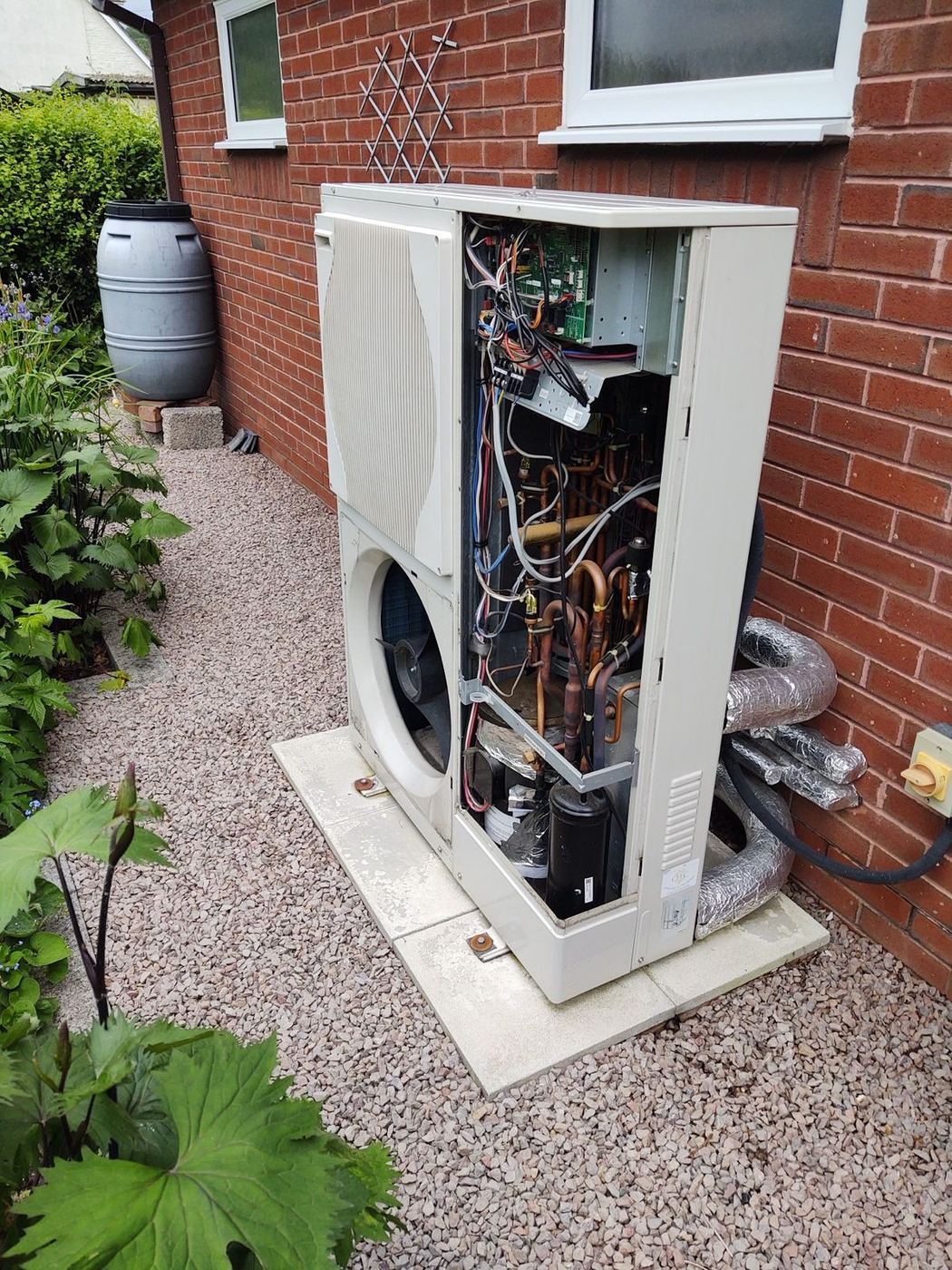 Heat pump unit open showing internal components and wiring