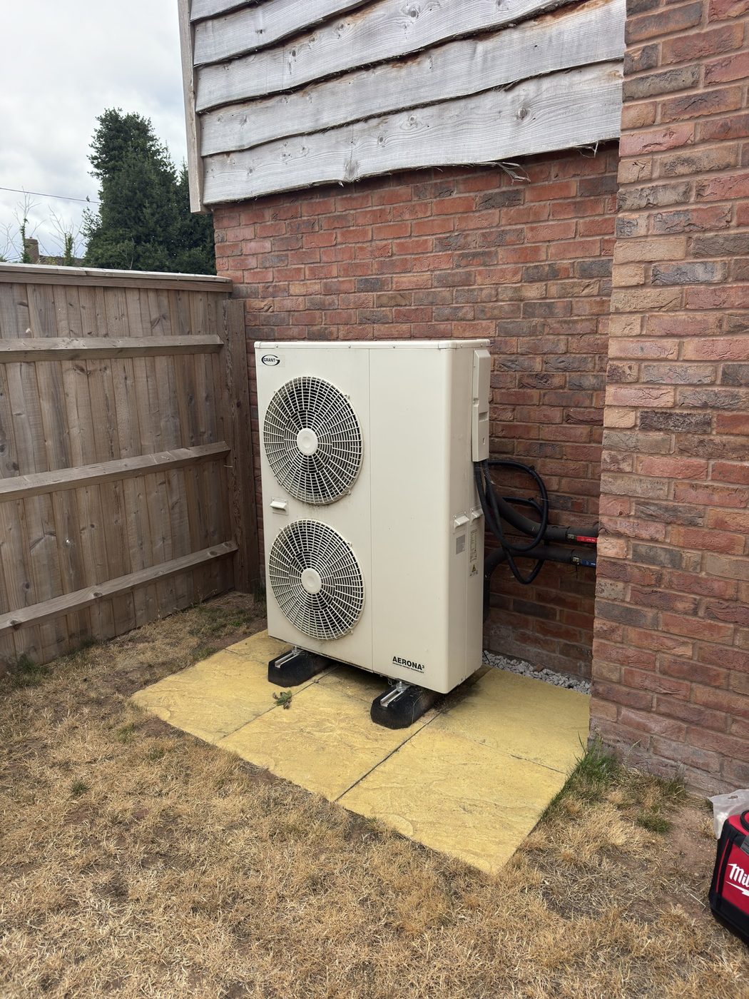 A Grant Aerona3 outdoor heat pump unit set on a level slab base on anti-vibration feet