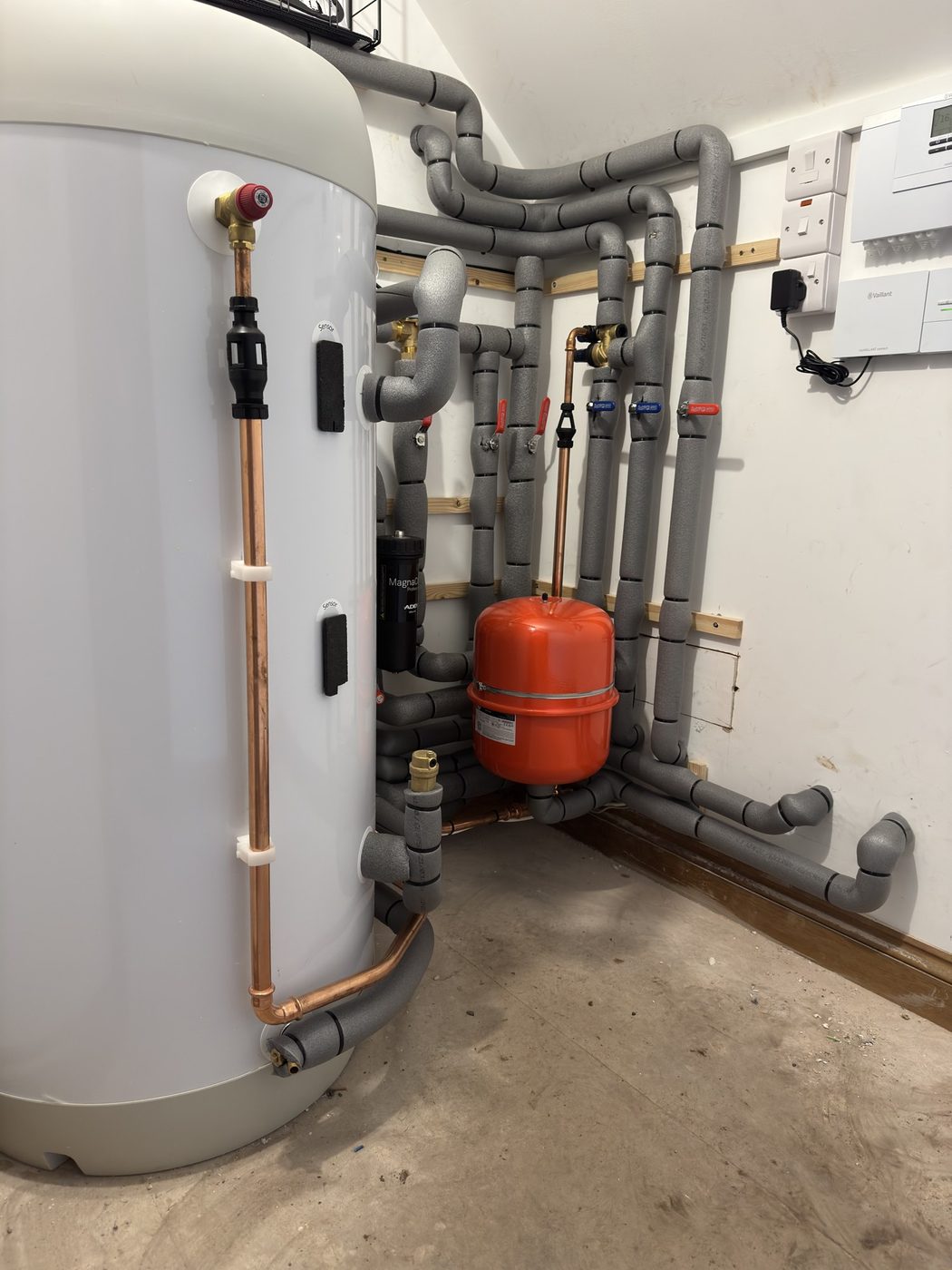 A complete heat pump plant room with cylinder, magnetic filter, expansion vessel and controls
