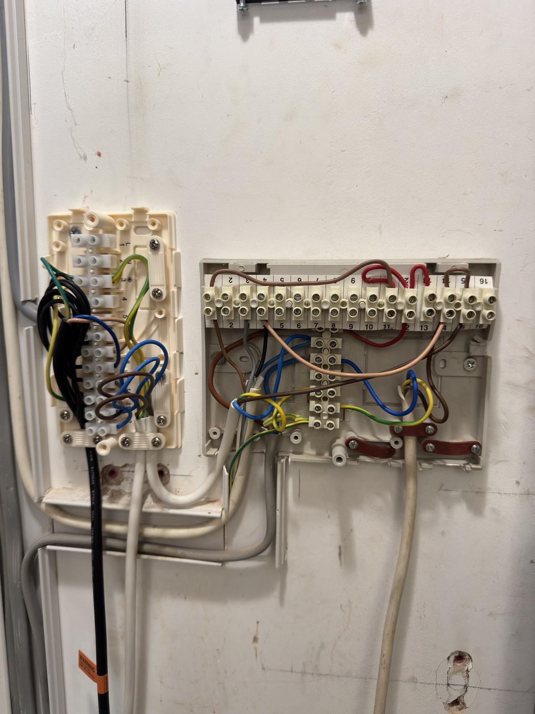 Electrical terminals and wiring inside a heat pump control enclosure, checked during fault finding