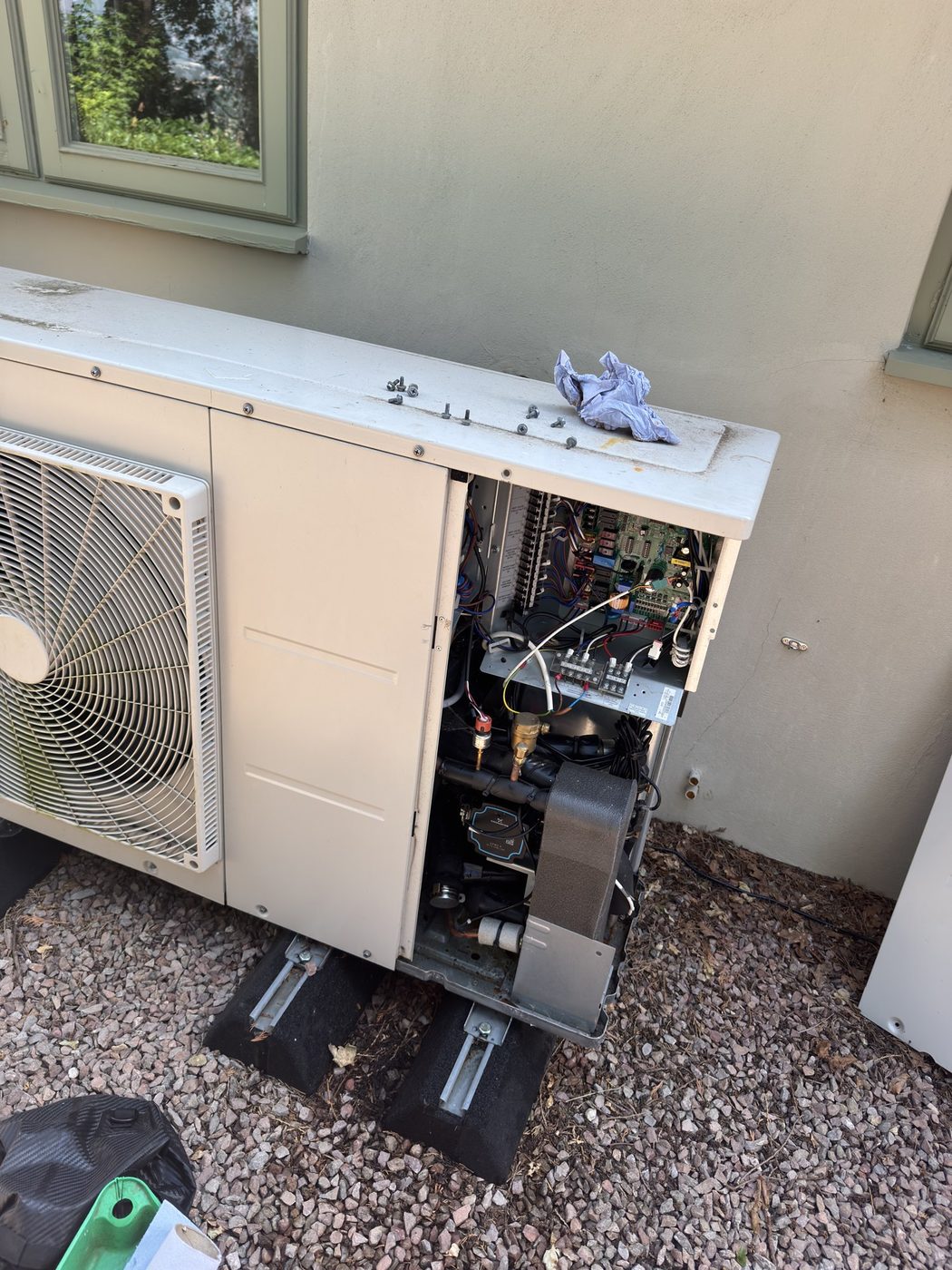 An LG outdoor heat pump opened up for repair, showing the control board and internal components