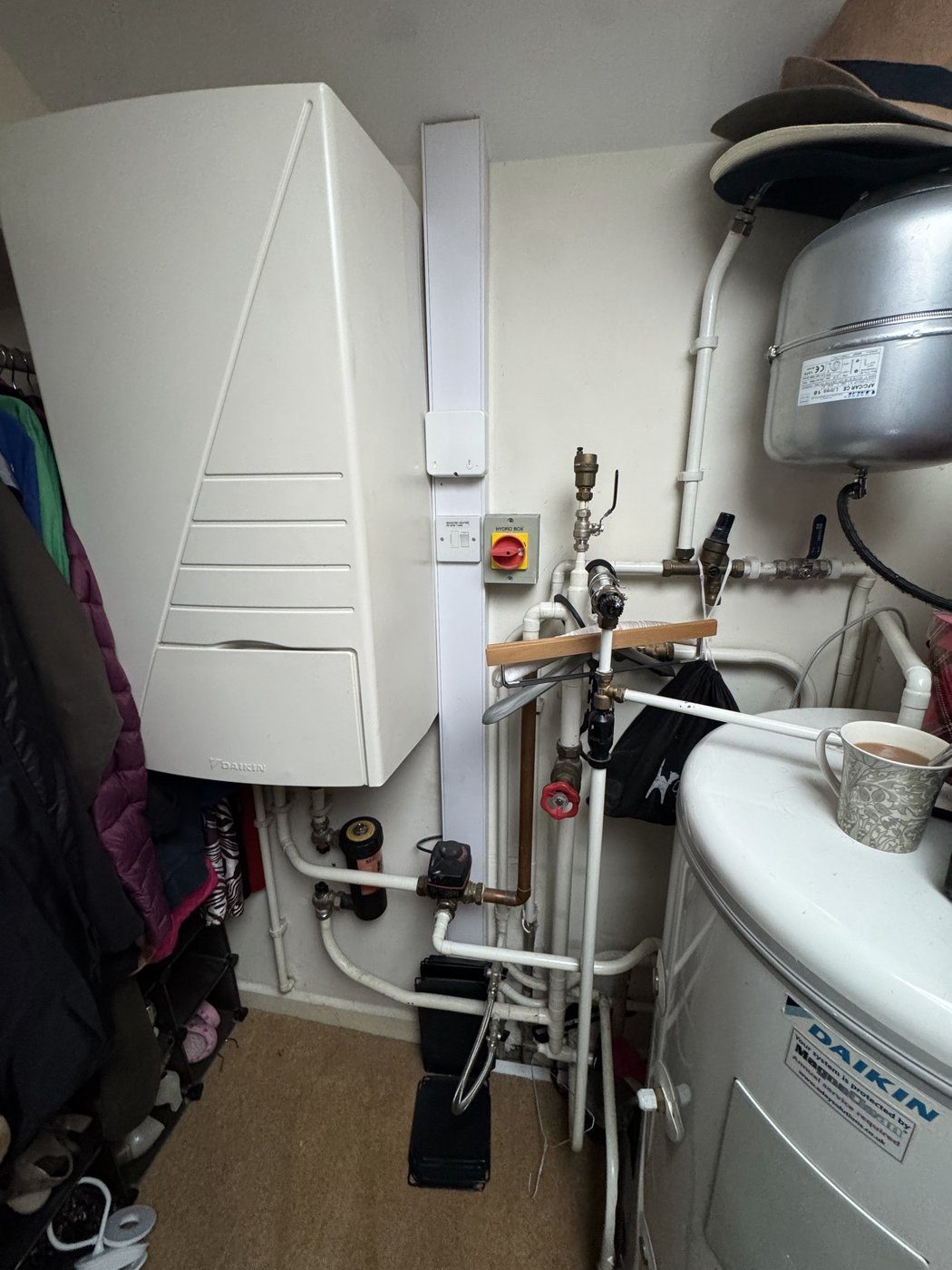 A Daikin indoor unit and hot water cylinder in a cupboard, checked over on a service